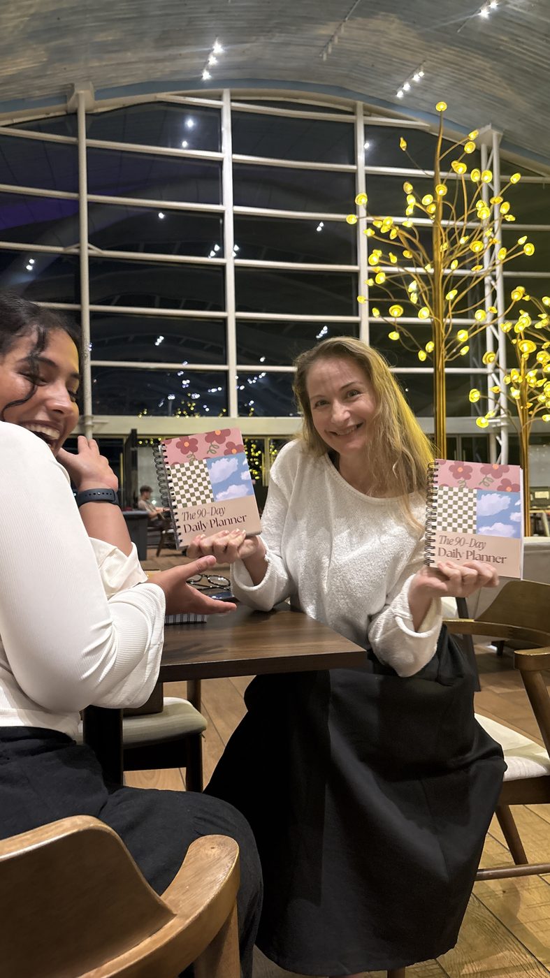 Tara and a customer holding the planner at the first sale